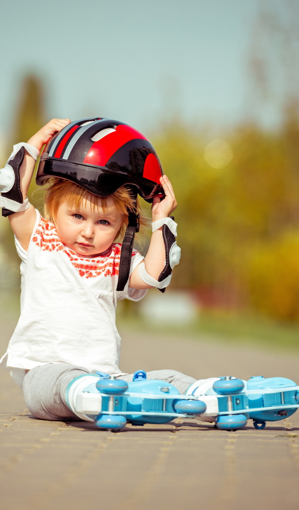 Маленький мальчик в шлеме и роликовых коньках