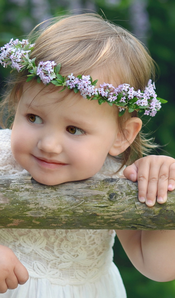 Маленькая кареглазая девочка с венком на голове