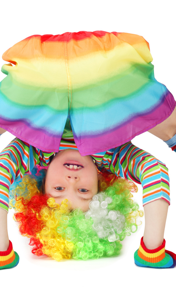 Маленькая смешная девочка в костюме клоуна на белом фоне