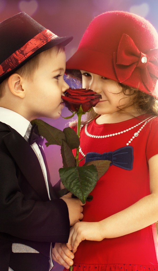 Маленькие девочка и мальчик с красной розой 