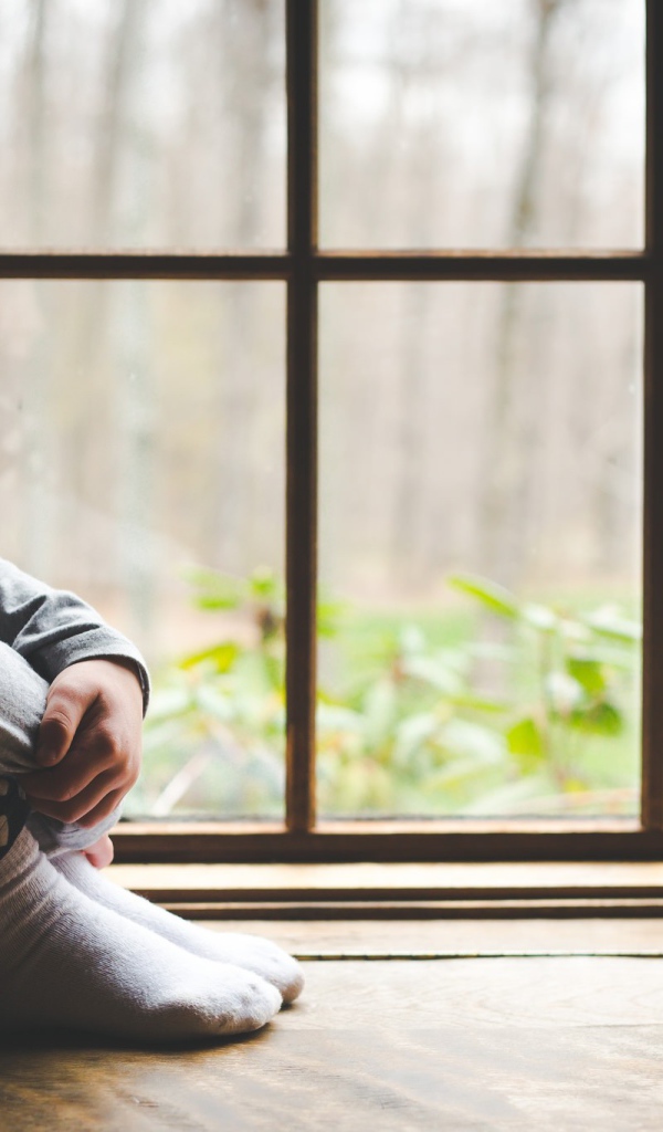 Маленькая девочка и цыпленок у окна 