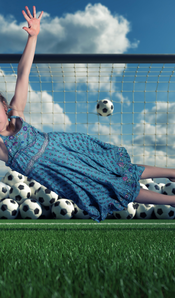 Маленькая девочка вратарь ловит мяч в воротах