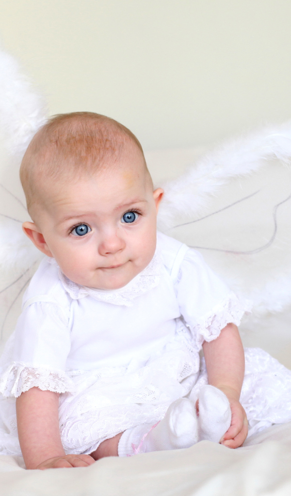 Маленькая девочка в красивом белом платье с крыльями