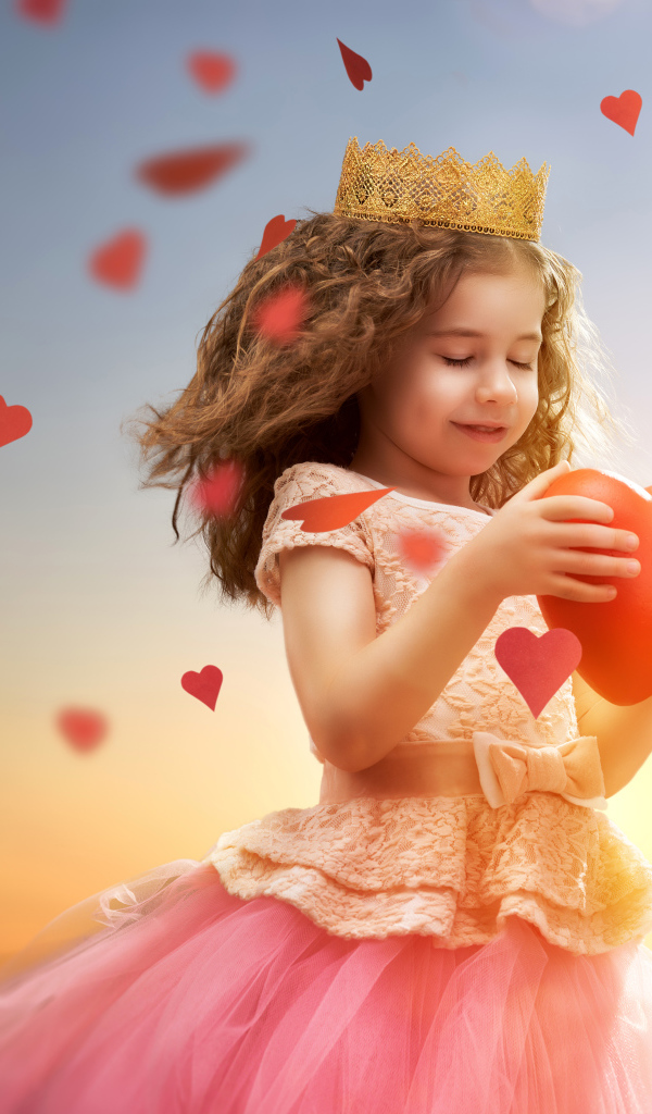 Маленькая девочка в костюме принцессы с красным сердцем в руках