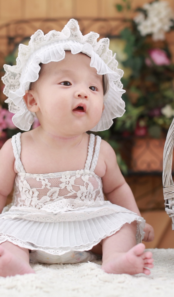 Маленькая девочка в белом платье с медвежонком в корзине