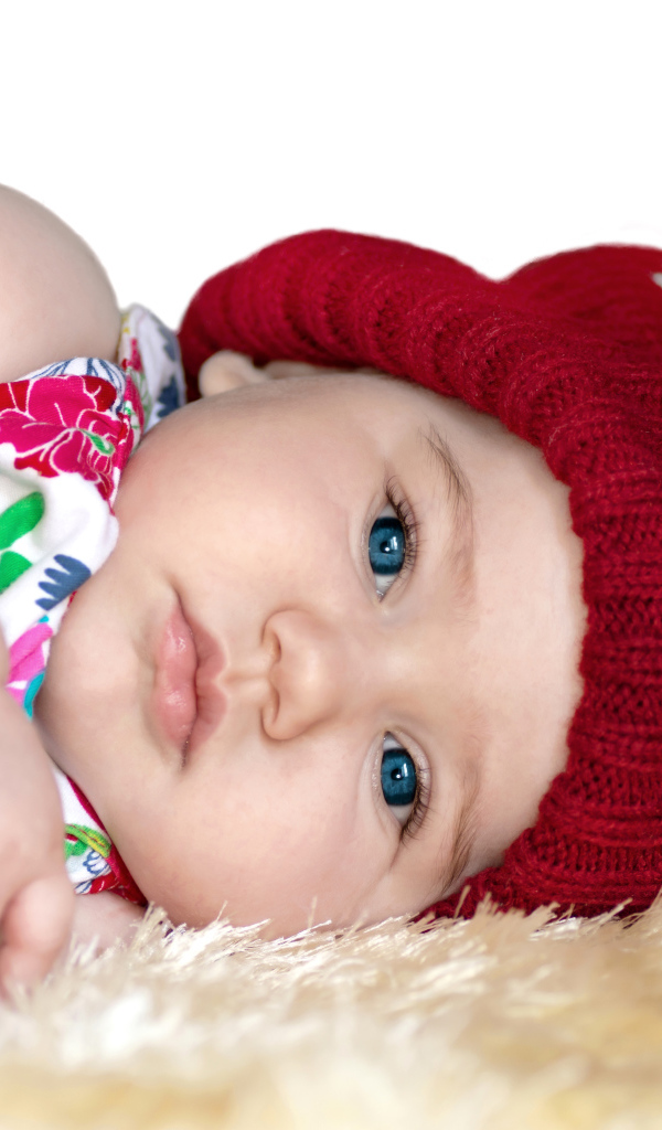 Маленькая девочка в красной вязаной шапке