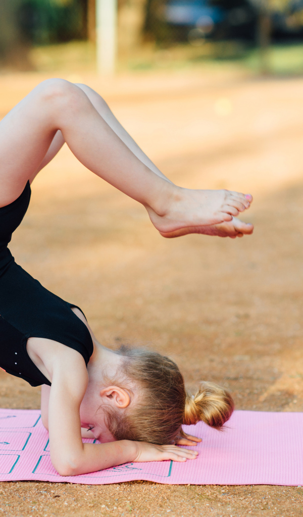 Маленькая девочка занимается гимнастикой
