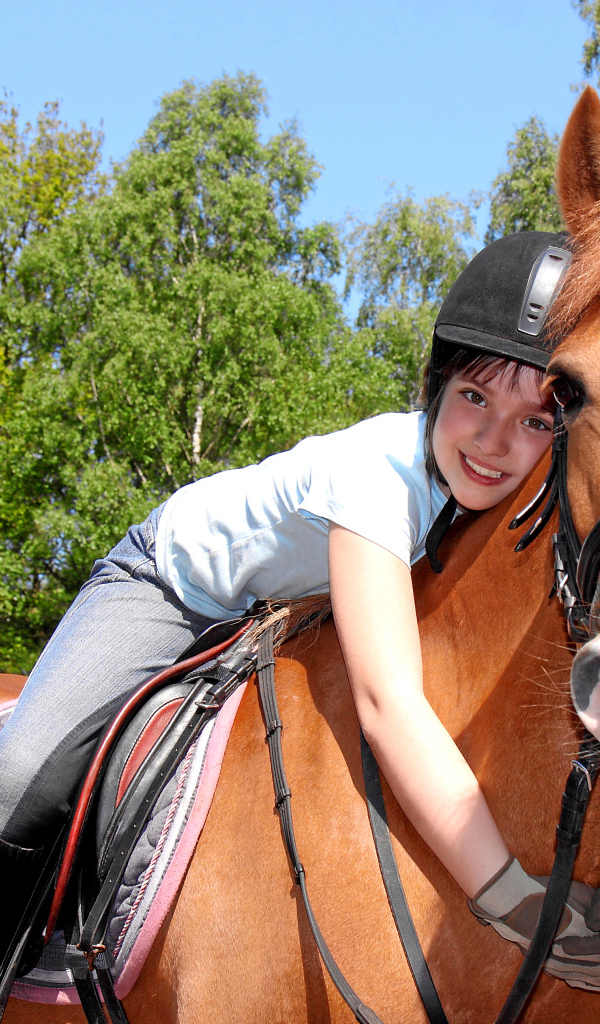 Маленькая девочка сидит на коричневой лошади