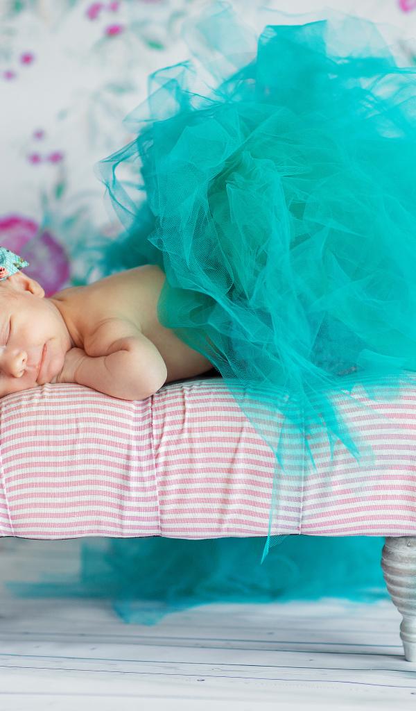 Маленькая девочка спит в красивом бирюзовом платье