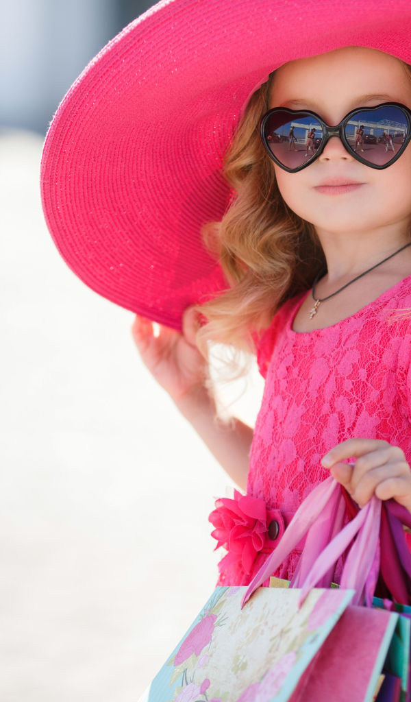 Маленькая девочка модница в большой розовой шляпе