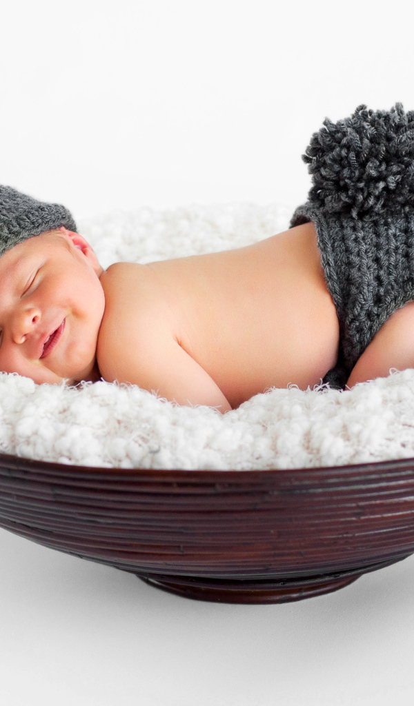 Маленький спящий грудной ребенок в вязаном костюме зайчика