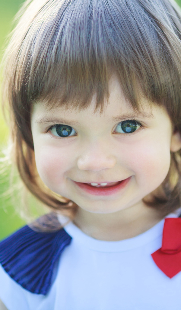 Милая улыбающаяся зеленоглазая маленькая девочка