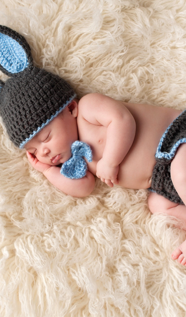 Спящий младенец в вязаном костюме зайца
