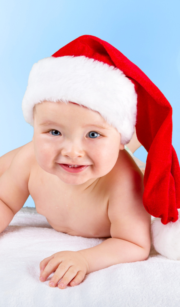 Улыбающийся грудной ребенок в новогодней шапке