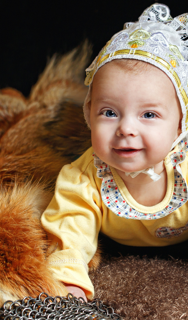 Улыбающаяся голубоглазая девочка в шапке