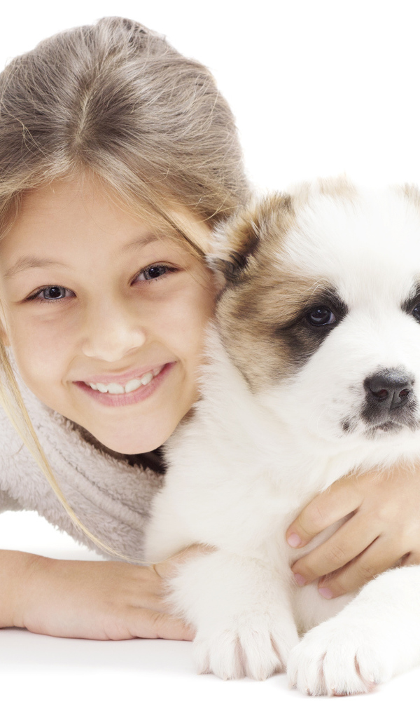 Улыбающаяся девочка с щенком алабая на белом фоне