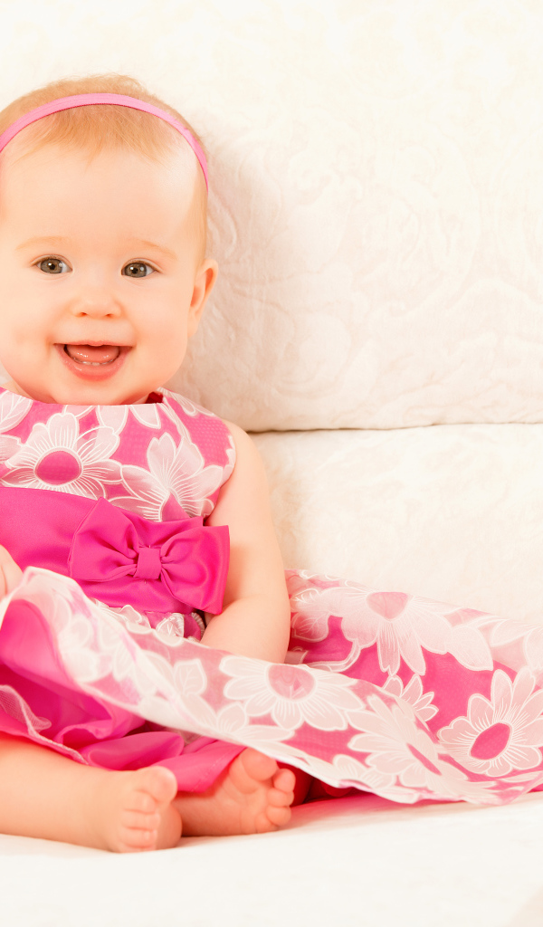 Улыбающаяся маленькая девочка в красивом розовом платье