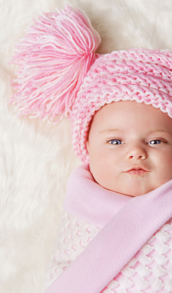 Милая малышка в красивой розовой шапке 