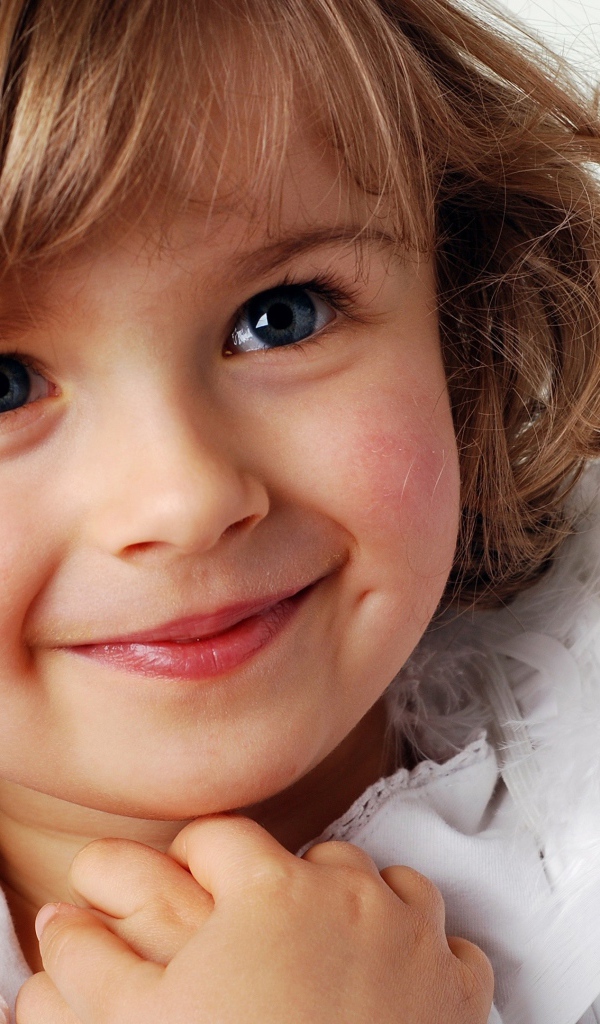 Маленькая голубоглазая девочка в костюме ангела 