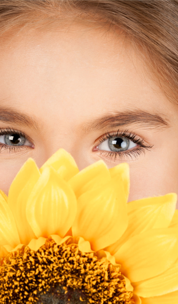 Взгляд маленькой девочки шатенки с подсолнухом в руках