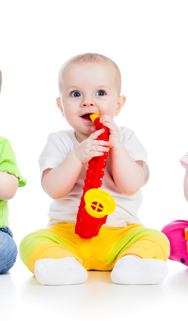 Три улыбающихся младенца играют на белом фоне