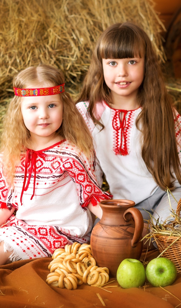 Две маленькие девочки в красивых костюмах с угощениями