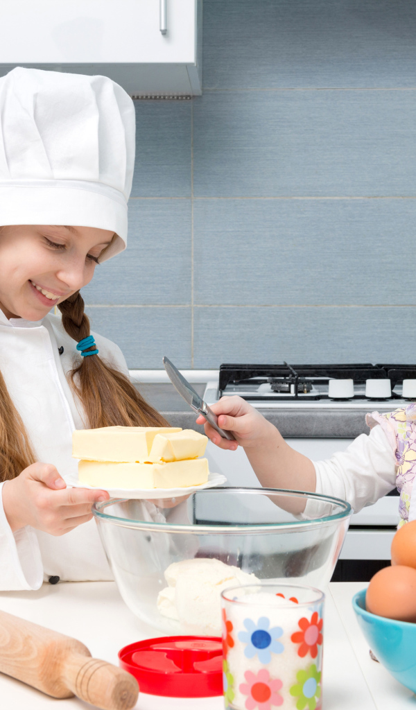 Две маленькие девочки на кухне готовят пирог