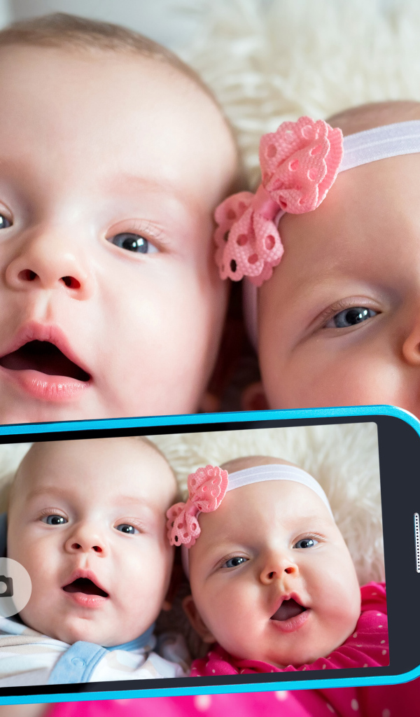 Два маленьких ребенка делают селфи на телефон