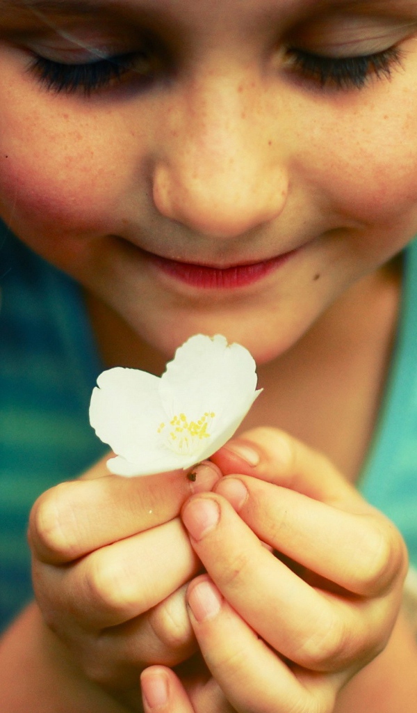 Маленькая девочка  держит белый цветок 