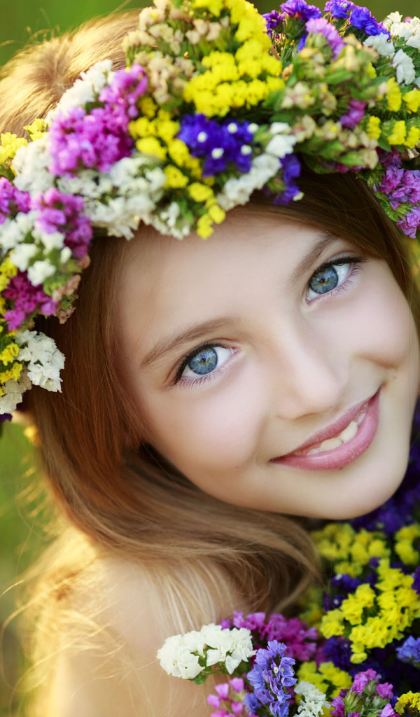 Маленькая голубоглазая девочка с полевыми цветами 