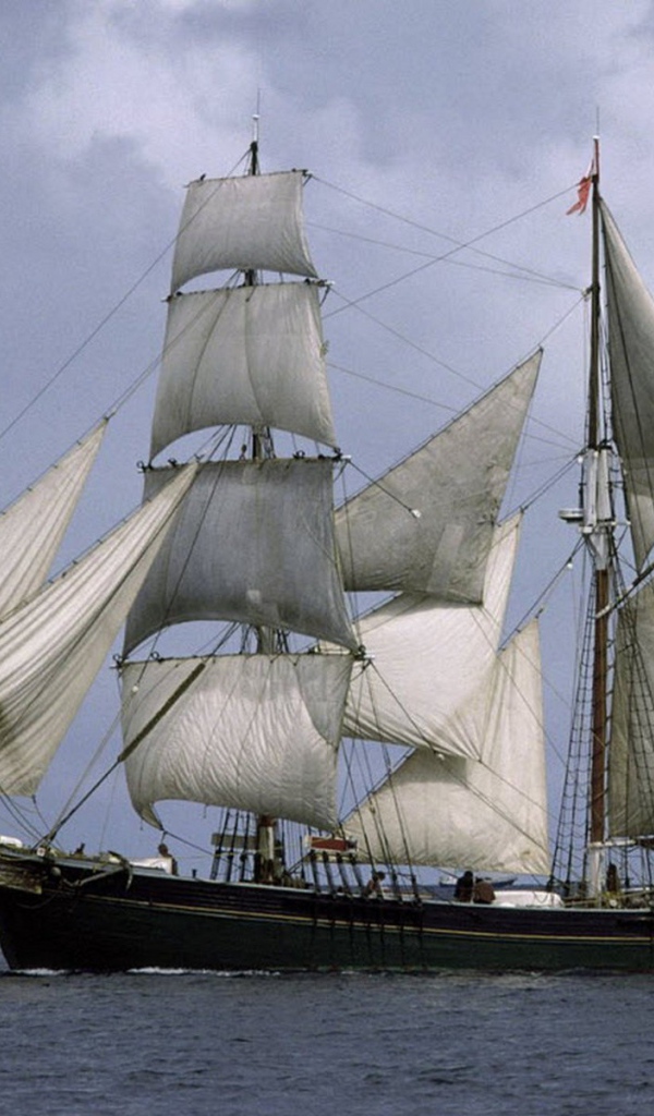 Корабль с белыми парусами в море 