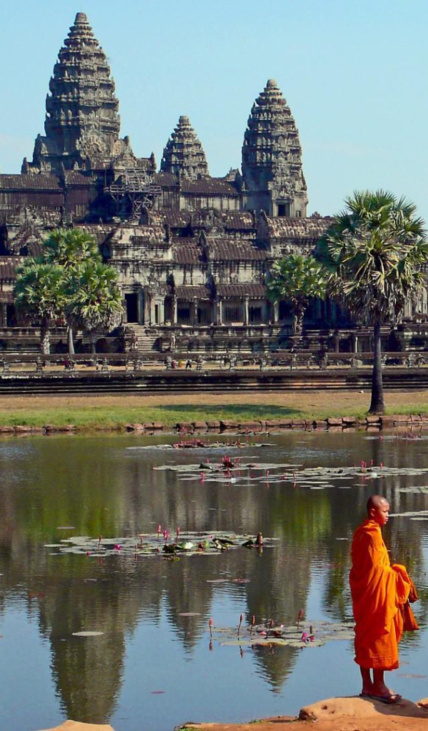 Монахи на берегу водоема у храмового комплекса Ангкор Ват 