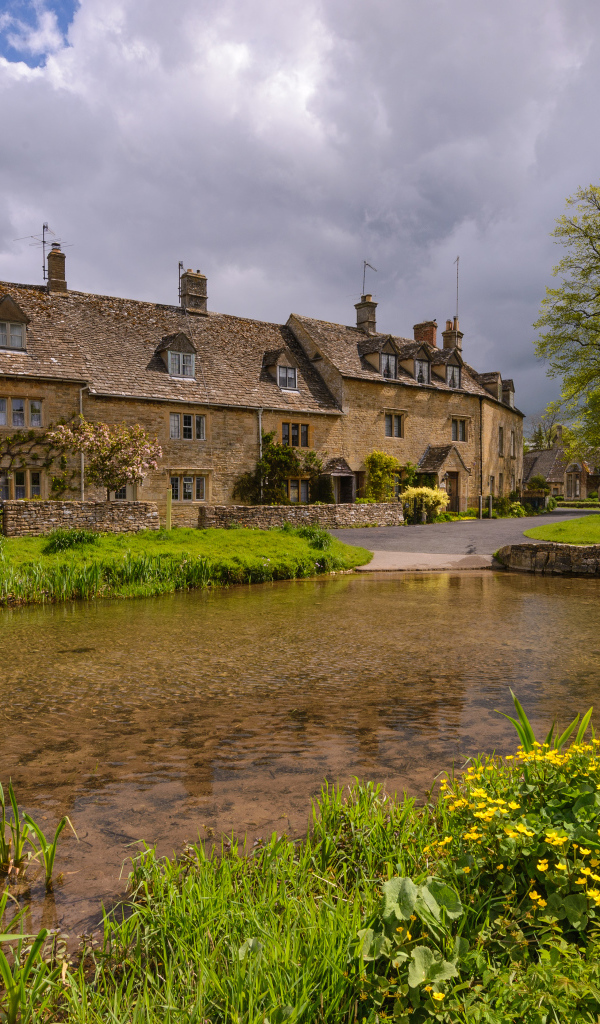 Дом у озера с покрытыми зеленой травой берегами, Англия