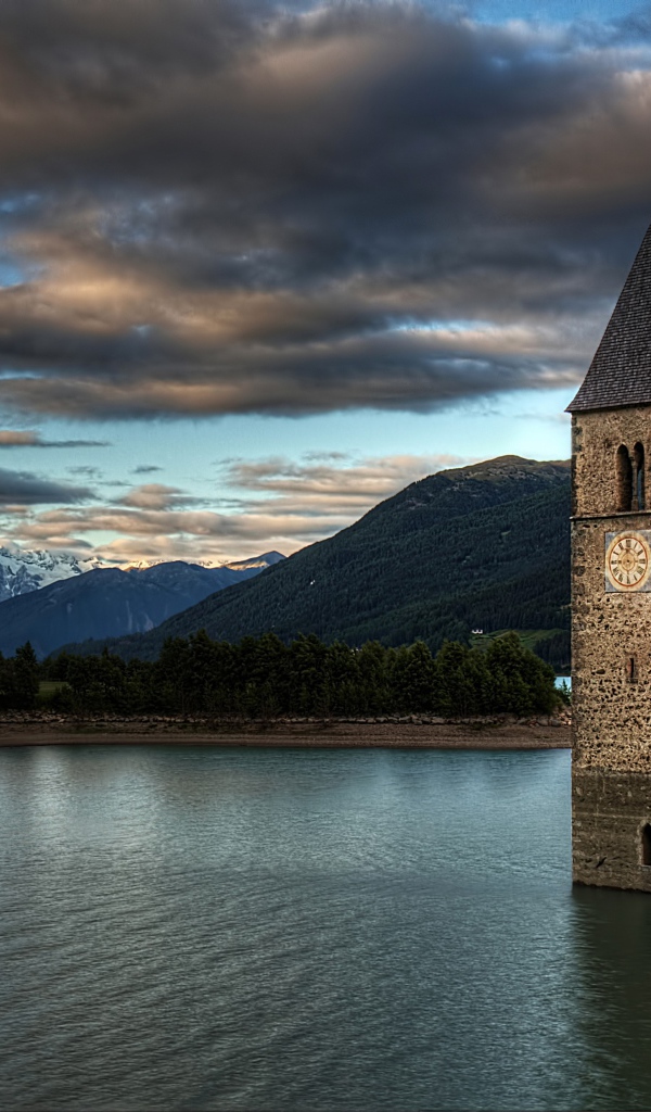 An ancient chapel in the background of a beautiful sky in the middle of Lake Rezia, Italy