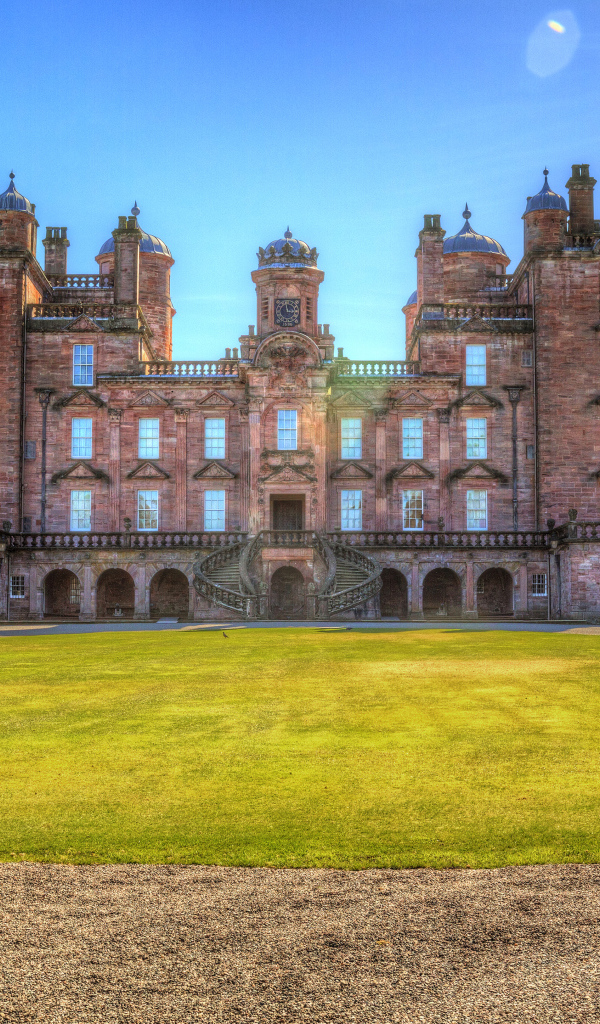 Замок Drumlanrig Castle с зеленым  газоном, Шотландия 