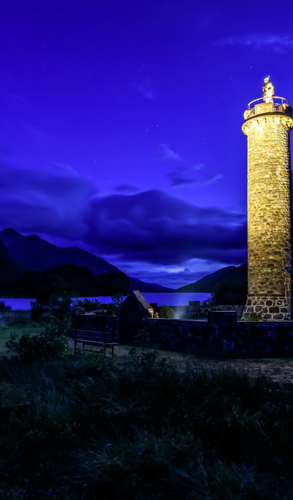 Ночной маяк у побережья на фоне гор, деревня Гленфиннан. Шотландия