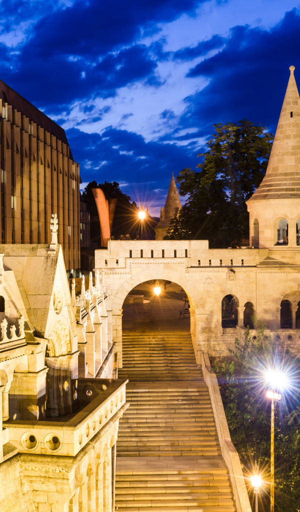 Высокая лестница в старинном замке в свете ночных фонарей, Будапешт