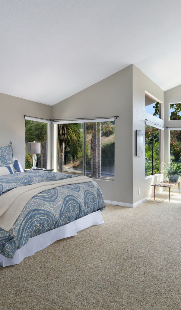 Уютная спальная комната в серых тонах с большими окнами