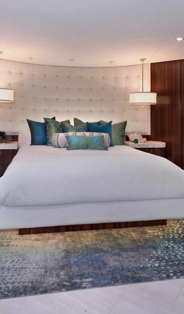 Большая кровать с белым покрывалом в спальне в коричневых тонах