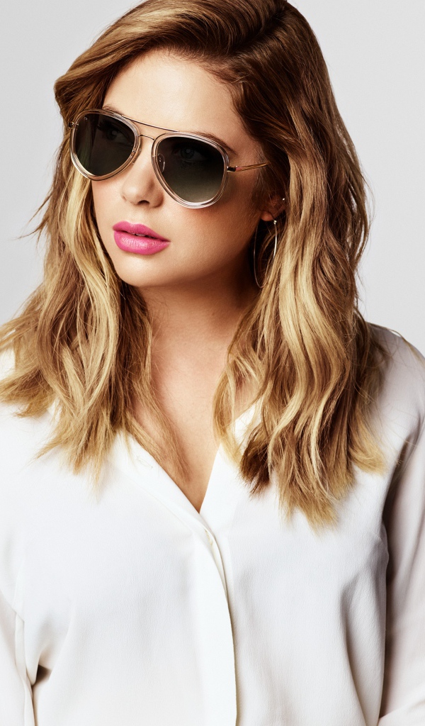 Актриса Эшли Бенсон в черных очках на сером фоне