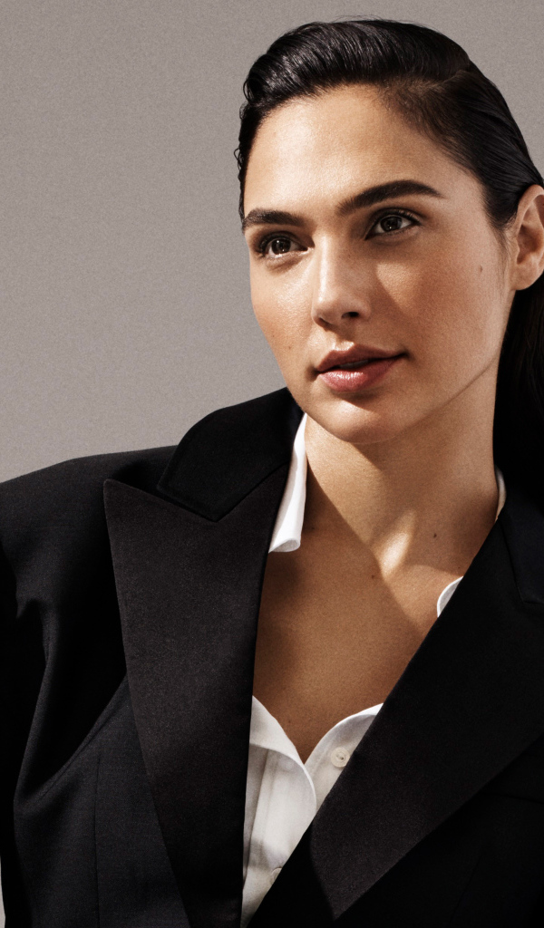 Актриса Галь Гадот в черном пальто на сером фоне