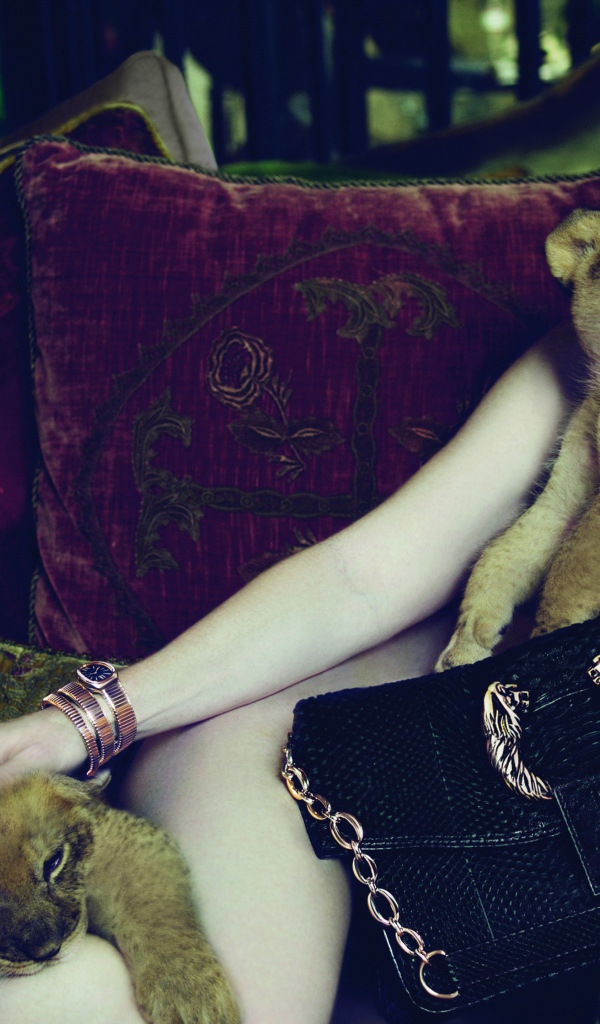 Актриса Джулианна Мур лежит на диване с маленькими львятами