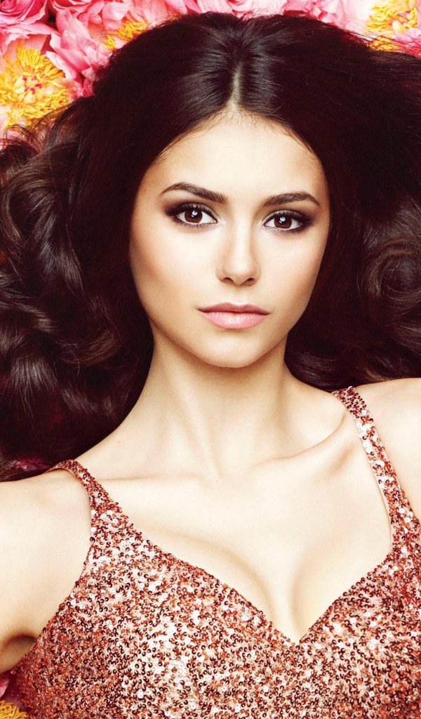 Красивая брюнетка, актриса Нина Добрев лежит на цветах