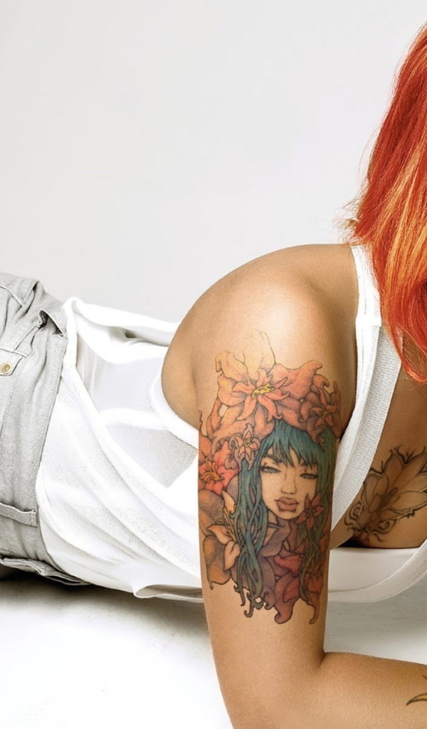 Красивая рыжеволосая девушка с пирсингом и татуировками