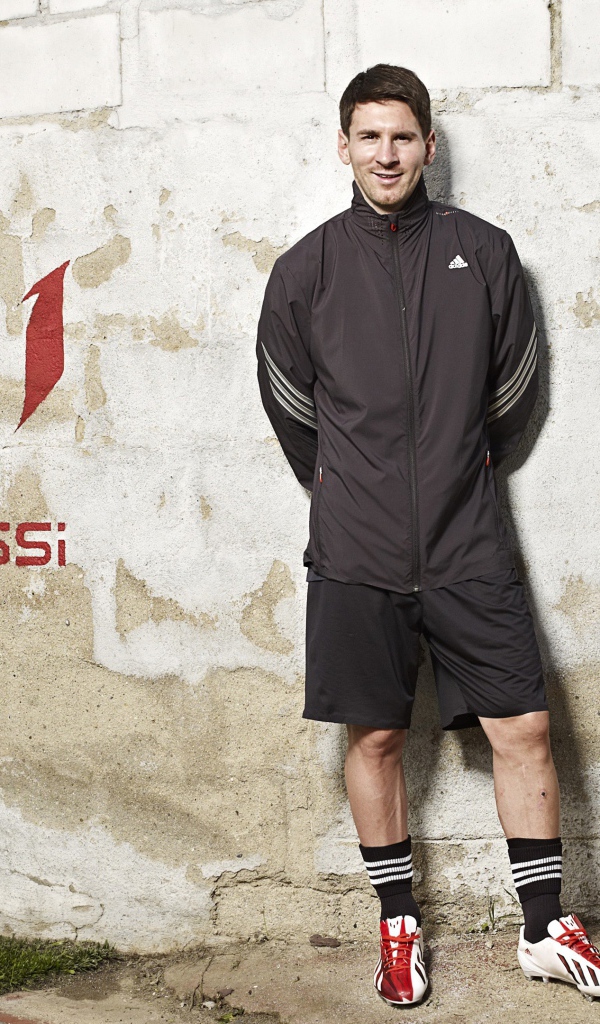 Футболист Лионель Месси позирует  на фоне стены 