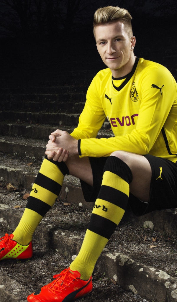 Немецкий футболист Марко Ройс сидит на ступеньках 