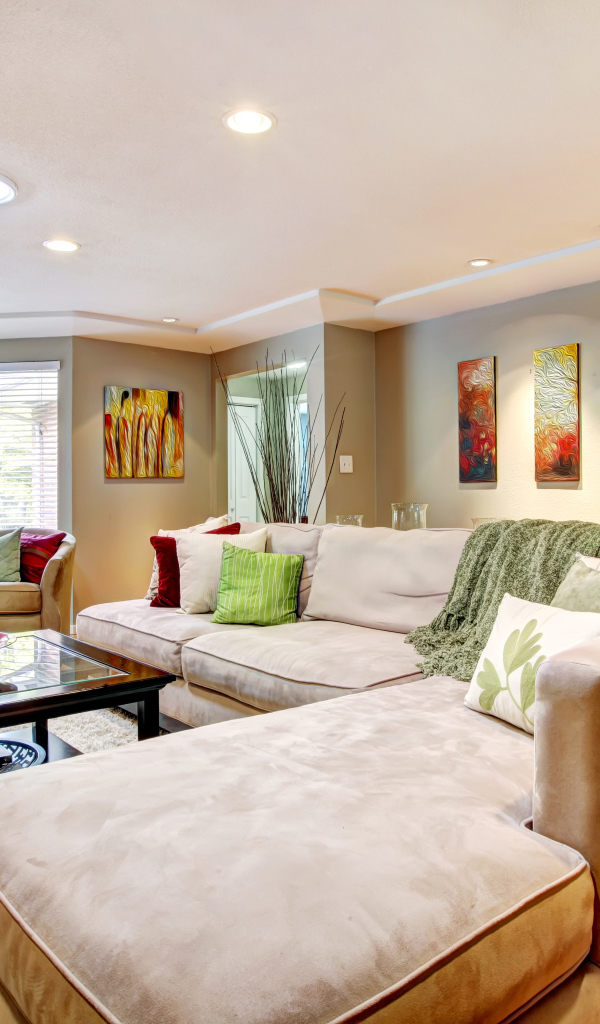 Большой диван в интерьере гостинной в пастельных тонах
