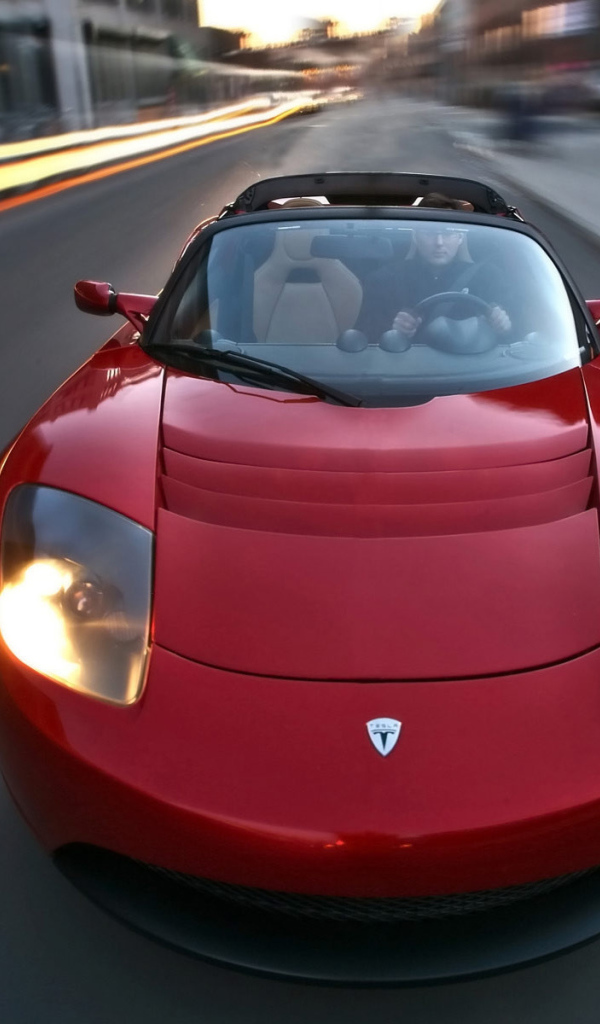 Красный электромобиль Tesla Roadster на трассе 