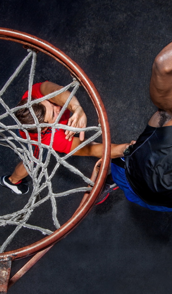 Баскетболист забрасывает мяч в кольцо 