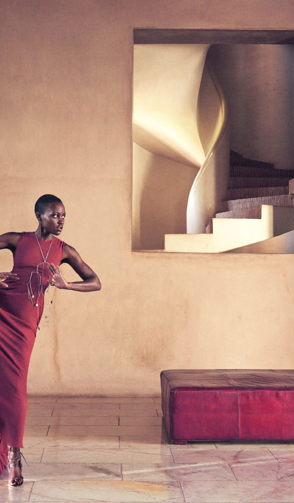 Молодая актриса Люпита Нионго танцует в красном платье